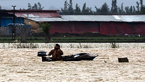 Yağmur sularının altında kalan tarlasını kayıkla gezdi